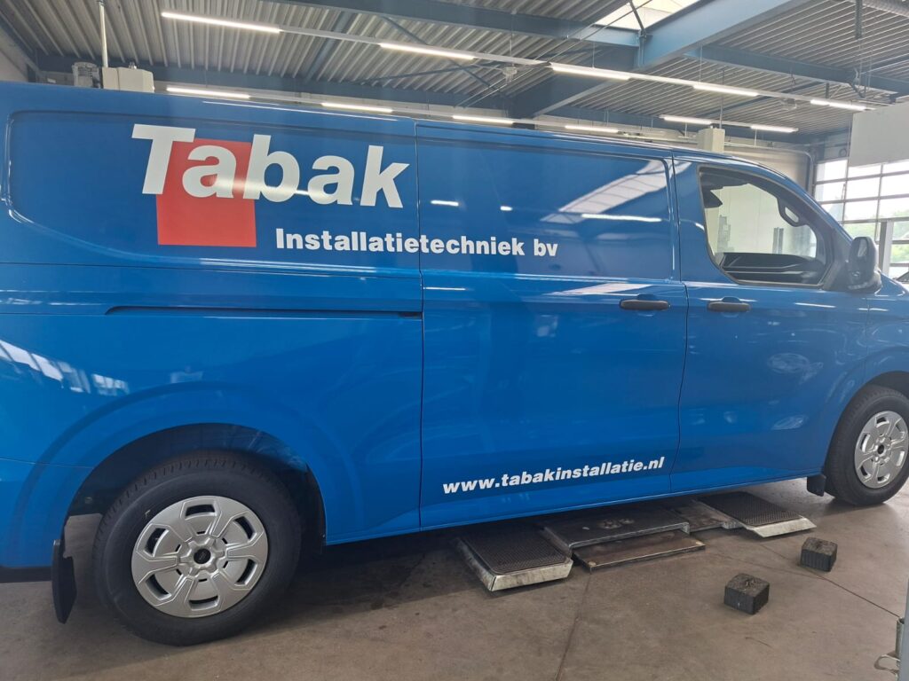 Blauwe bestelbus met de belettering van Tabak Installatietechniek op de zijkant
