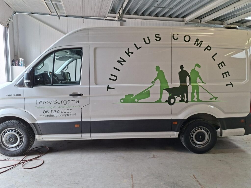 Witte bestelbus met groene belettering van Tuinklus Compleet over de hele zijkant