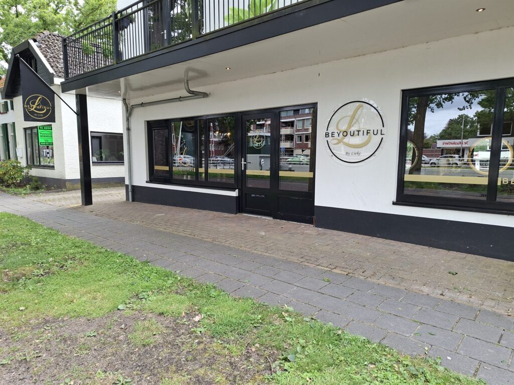 Voorgevel van een salon met beletterde etalageruiten